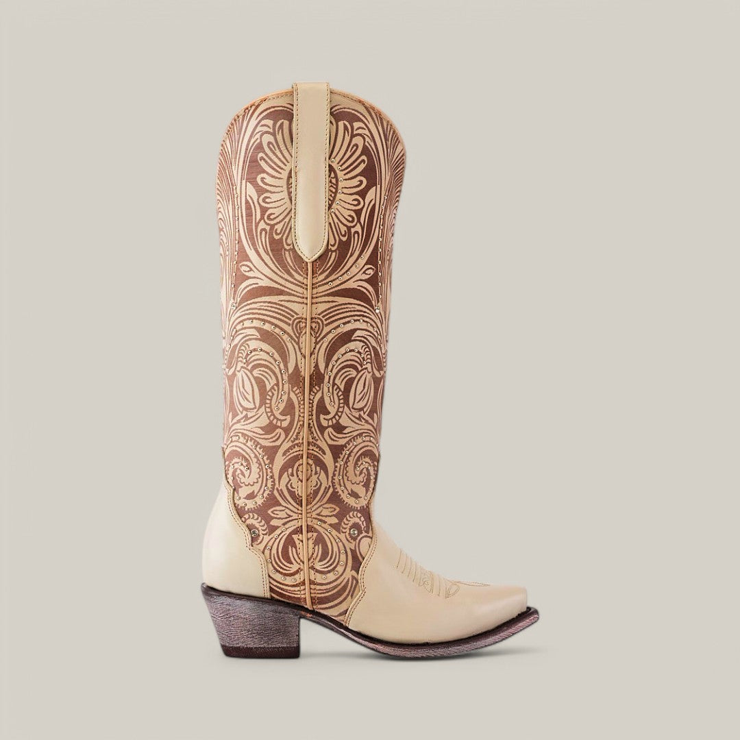 A side view of the Cavalier Laser Cream boot showcases cream leather with intricate brown embroidery. The tall shaft and snip toe stand out against a plain light gray background, embodying its elegance.