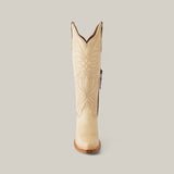 The Kellie Bone Leather Sole boot, featuring a tall shaft and snip toe design, is displayed against a light gray background. This cream-colored cowboy boot showcases intricate stitching and decorative embroidery on its sturdy leather sole.