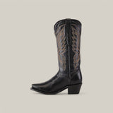 The Miranda Clayton Black Leather Boot is displayed against a plain beige background, featuring decorative stitching on the upper shaft. Its snip toe and chunky heel design blend style and sophistication seamlessly.