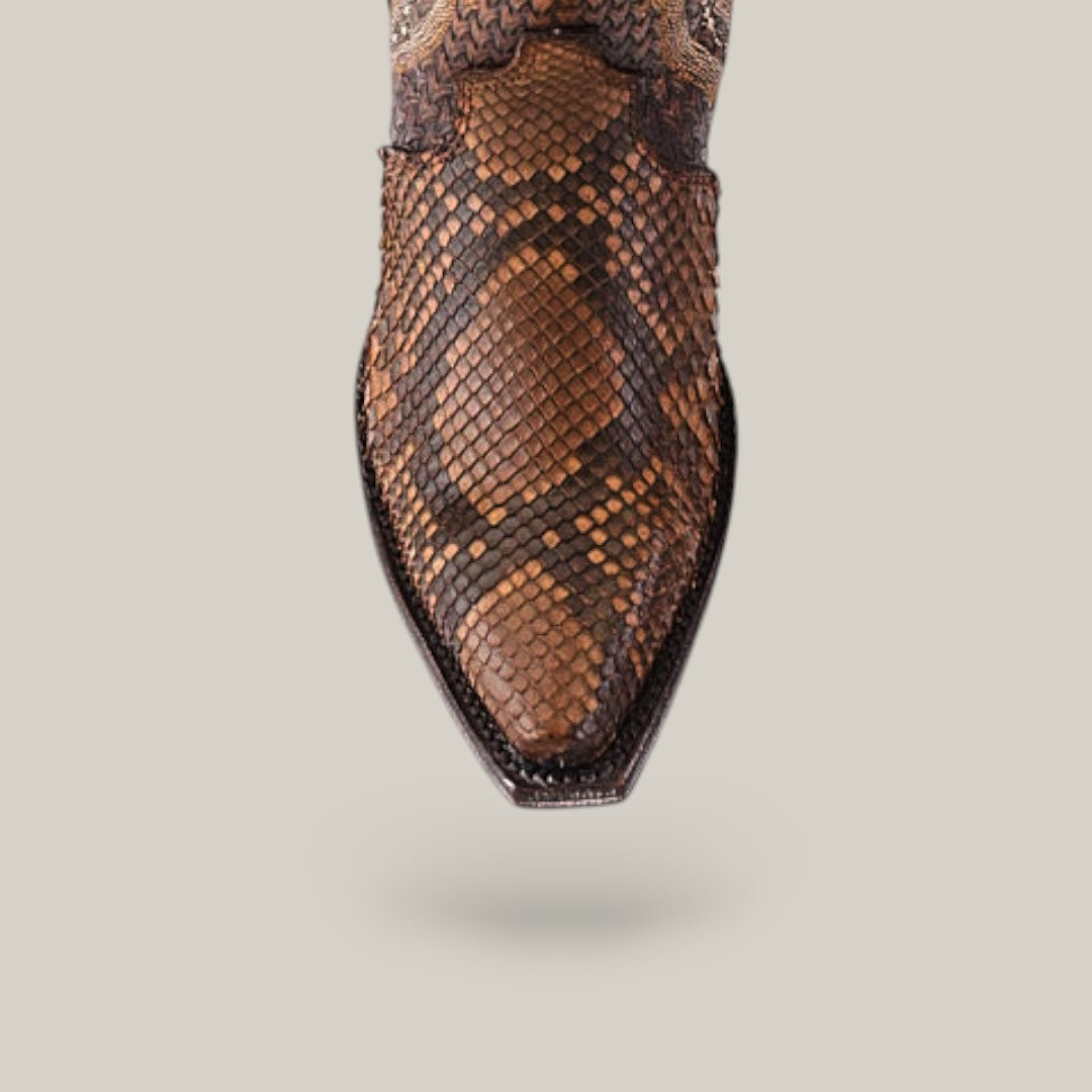 The Athala Exotic Python Tamarindo boot flaunts a snip toe crafted from premium python leather, showcasing a detailed pattern of dark and light brown scales that emphasize its Western roots against a plain light gray backdrop.