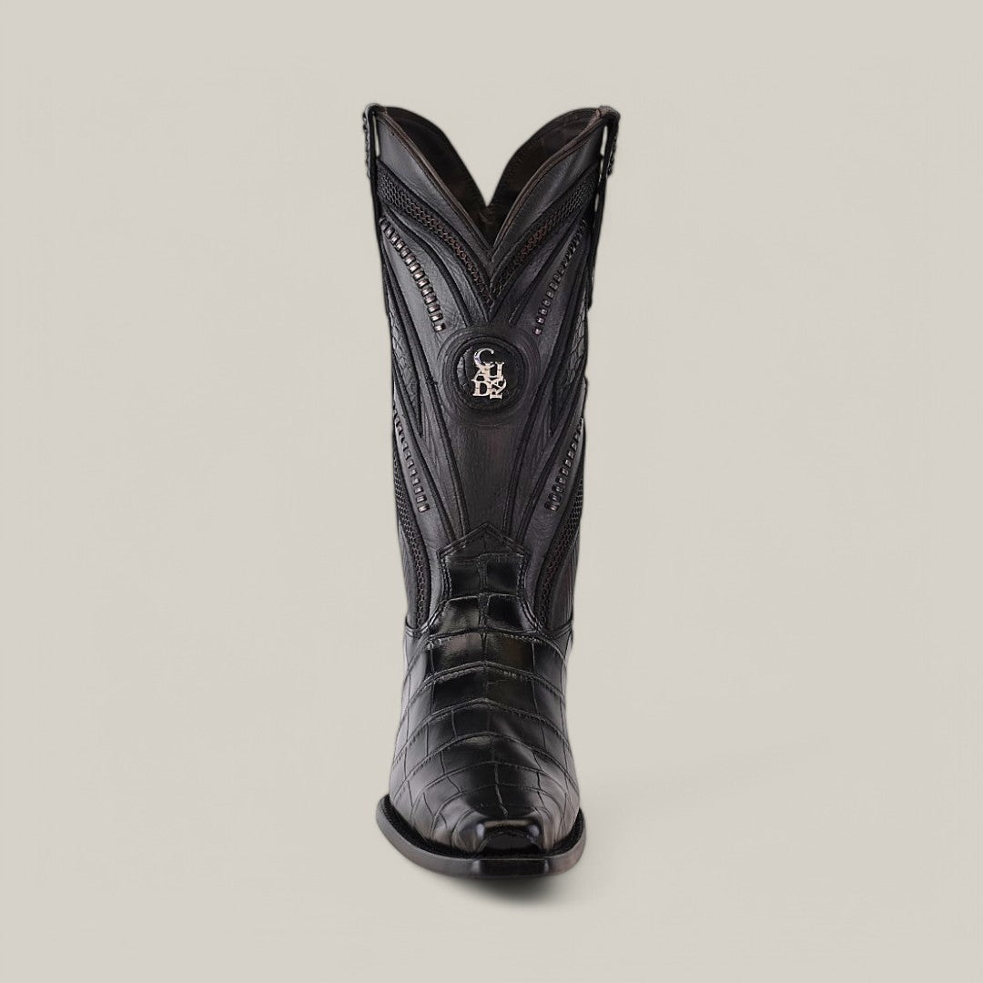 The Alligator Belly Black - Narrow Square Toe - IMPERIO boot features a single black design with intricate stitching, textured details, and an emblem near the top, crafted from alligator belly leather against a plain gray background.