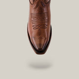 A brown Miranda Clayton boot with a leather sole and mid shaft, showcases intricate stitching on the upper. It features a snip toe and smooth leather finish, all set against a light gray background.