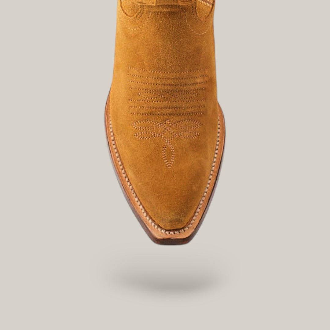 The Kellie Suede Gold Leather Sole boots feature premium tan suede with intricate stitching. These snip-toe cowboy boots have a slightly raised heel, creating an elegant statement on a plain background.