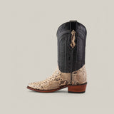 The Exotic Python - Natural - Snip Toe cowboy boot has a black upper with intricate stitching, a textured tan lower made from exotic python leather, a snip toe design, and a brown wooden heel, all set against a plain light background.