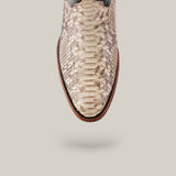 Close-up of the Exotic Python Natural boot, featuring luxurious natural python leather with intricate scales, a round toe, brown sole, and set against a neutral backdrop. The design appears gracefully suspended with a subtle shadow beneath.