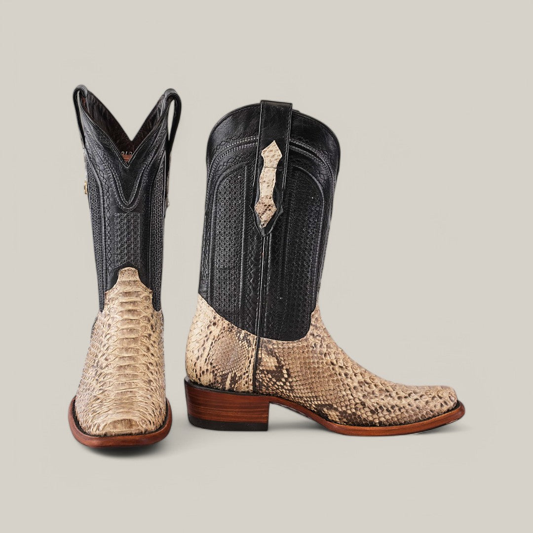 The Exotic Python boots feature black uppers with tan python leather lower parts and toes, set against a light gray background. One boot faces forward while the other shows the heel and sole, making them a true statement piece.