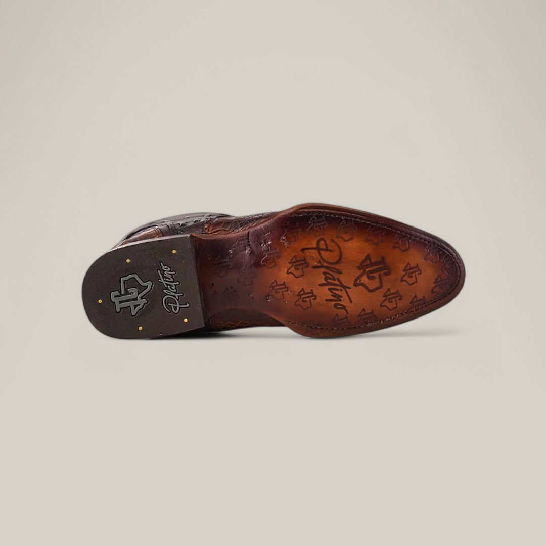 The image displays the bottom of an Exotic American Alligator - Europe Fawn - Round Toe shoe. It has detailed engravings, patterns, two metallic rivets, a signature, and a logo near the heel on a beige background.