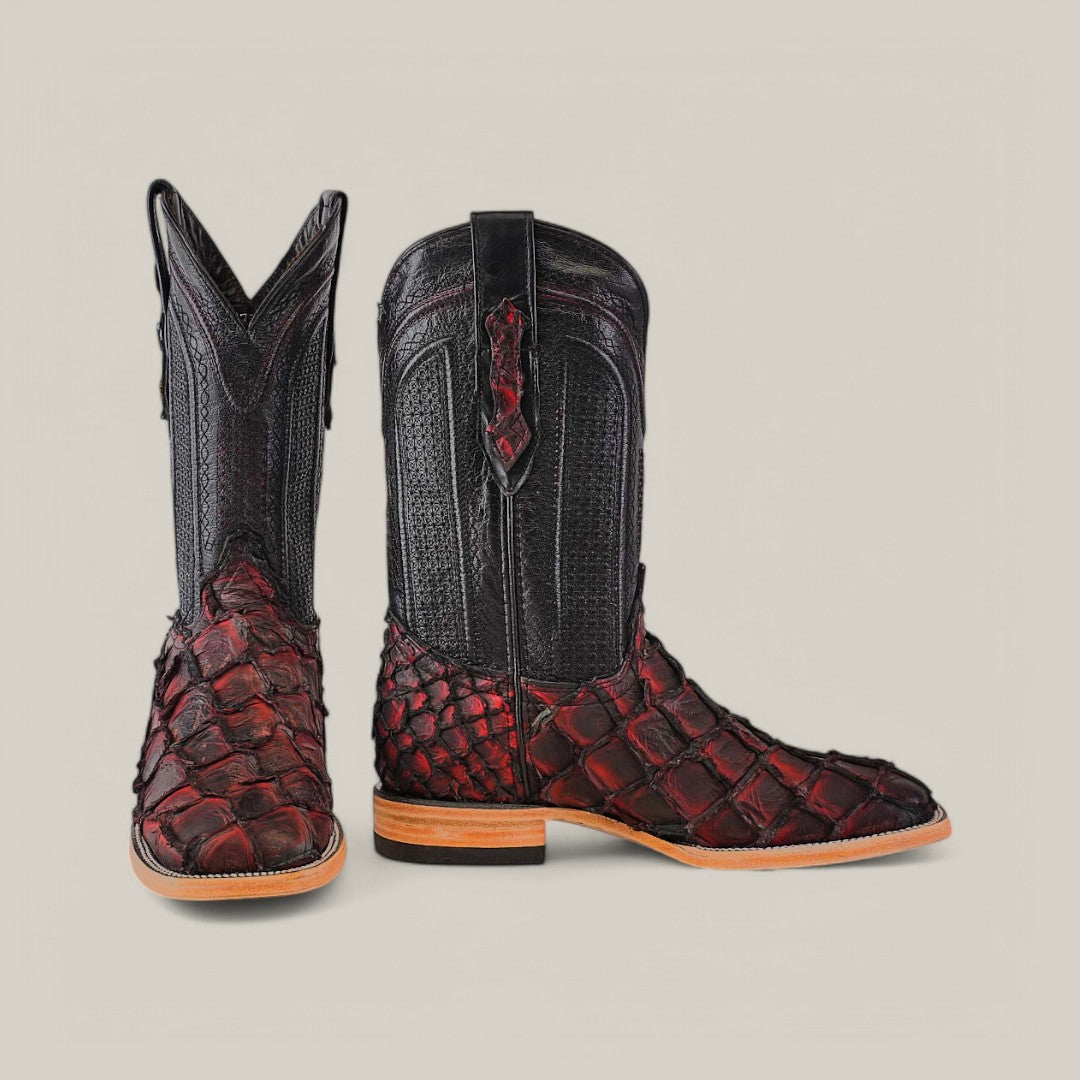 Exotic Pirarucu Fish boots in red, featuring intricate scale patterns and textured black leather accents, with square toes and wooden soles. These distinctive footwear pieces are displayed against a plain background.