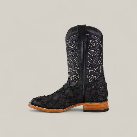 The Exotic Patchwork Pirarucu Fish - Matte Black - Square Toe features white stitching, a unique textured leather pattern, and a light brown eco-friendly wooden sole, shown on a plain light gray background.