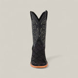 The Exotic Patchwork Python - Matte Black - Square Toe boot, featuring decorative stitching, textured patterns, and a light brown sole, stands upright against a plain light gray background.