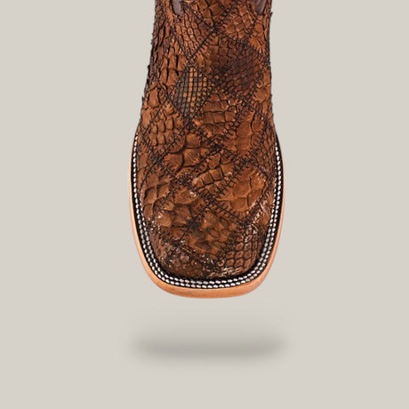 Close-up of the Exotic Patchwork Python - Tamarindo - Square Toe boot, highlighting its brown premium python skin, patterned leather surface, intricate stitching, and square toe design against a light background.