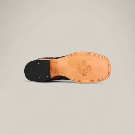 A detailed view of the Exotic Patchwork Python - Tamarindo - Square Toe dress shoe, highlighting its tan leather sole with stitching, black heel, and branded arch stamp—all crafted from premium python skin for a refined look.