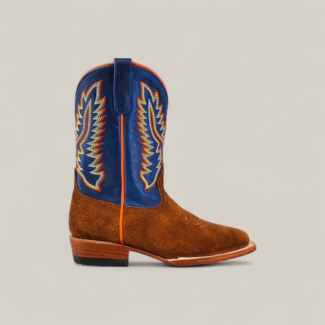 A single childrens Diamond Suede Ocre - Square Toe boot with a brown foot, blue shaft with yellow, red, and white stitching, low wooden heel, and pull strap.