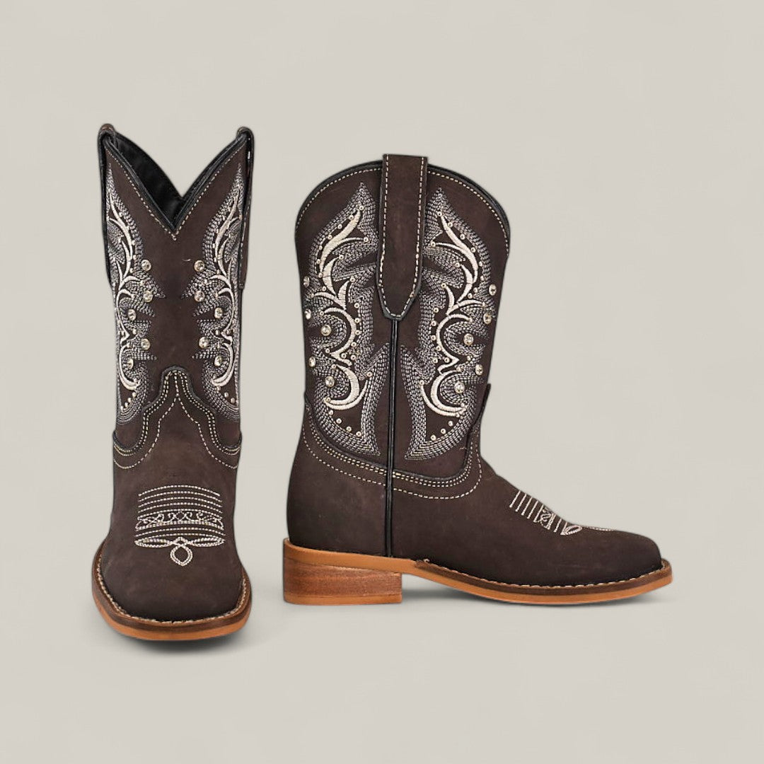 The Amara Suede Oxford - Square Toe Kids Boots feature dark brown suede, light embroidery, wooden heels, and a square toe, displayed upright on a neutral background to highlight their quality craftsmanship.