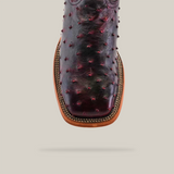 Top view of the Exotic Full Quilt Ostrich Boot in Black Cherry showcases a unique textured pattern and square toe. The rich burgundy hue pairs beautifully with the tan sole and edge stitching, all set against a plain light gray background for added elegance.