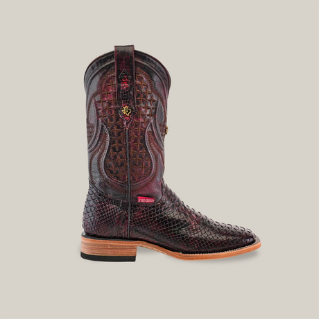 The Exotic Python - Black Cherry - Square Toe boot features intricate stitching on a burgundy hue with a scale-like python leather pattern. It has a light brown stacked heel and sole complemented by decorative elements on the shaft.