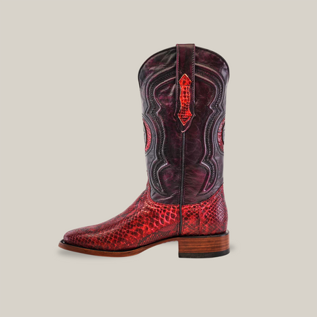 A single Exotic Python - Ruby - Square Toe cowboy boot, crafted from ruby-toned python leather, features intricate stitching and detailed patterns. The design is complemented by a wooden heel, perfectly blending elegance with Western flair against a plain off-white background.