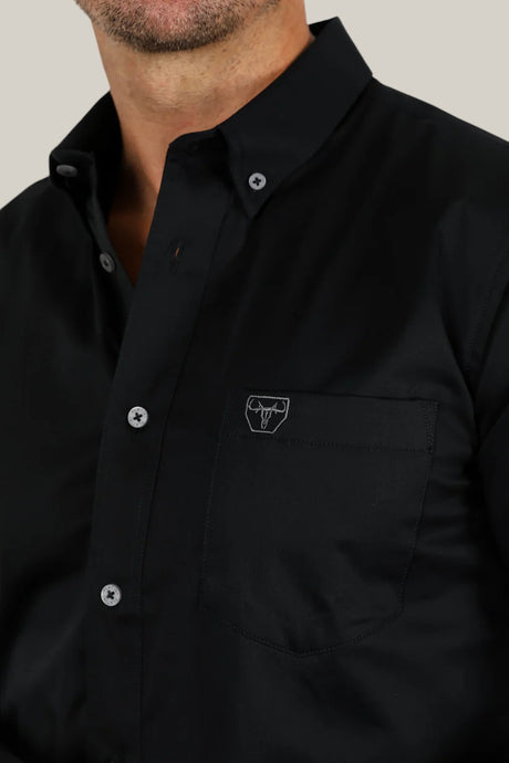 Wearing the Men’s Single Pocket Logo Modern Fit Stretch Dress Shirt - Black (CTL9258) with a bull logo on the chest pocket, this sleek shirt features a button-down collar and gray buttons, crafted from stretch fabric for a contemporary fit.