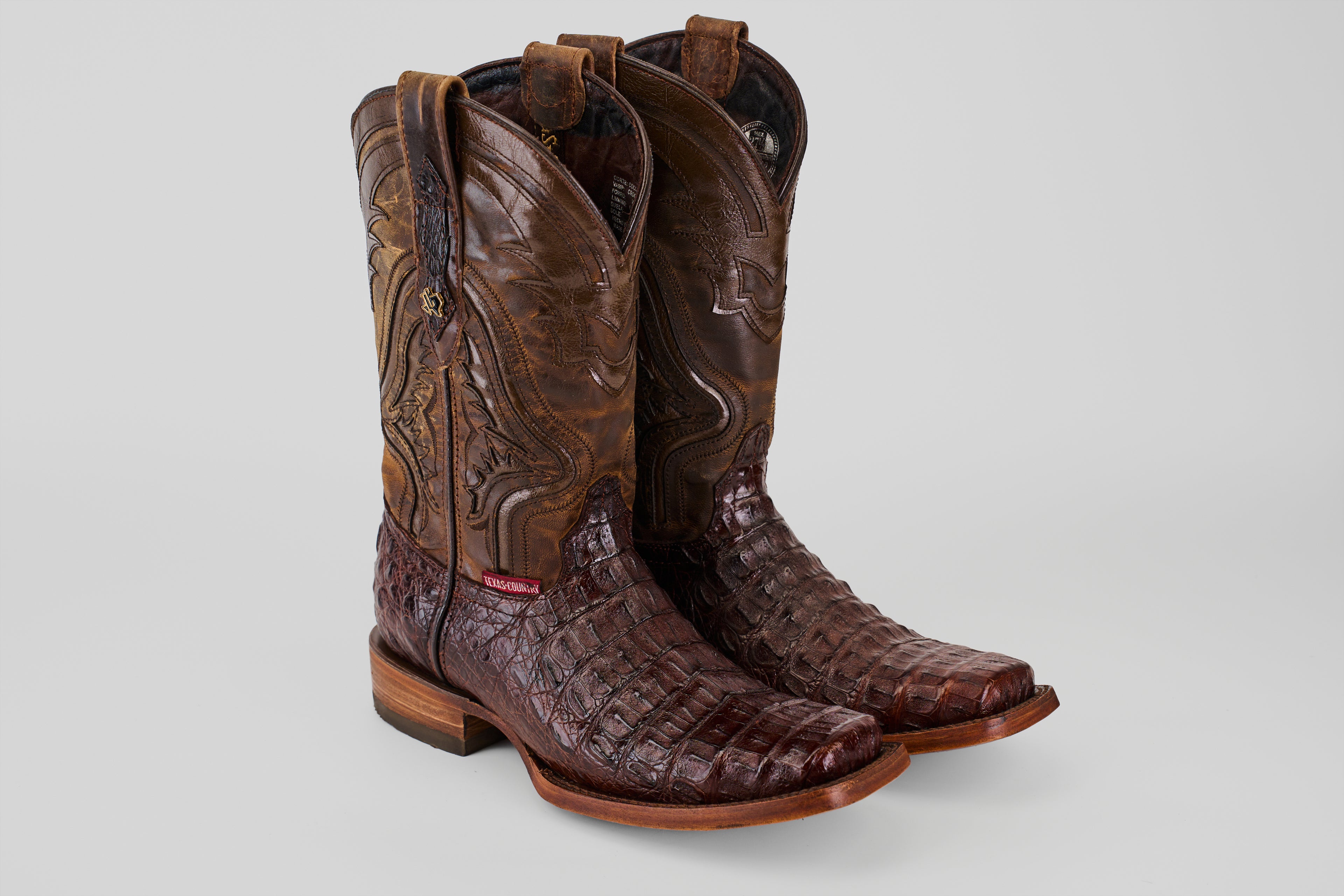 A pair of Exotic Caiman Hornback - Brown - Rodeo Toe boots with detailed shaft stitching and textured, genuine caiman leather on the foot, displayed side by side on a plain light background.