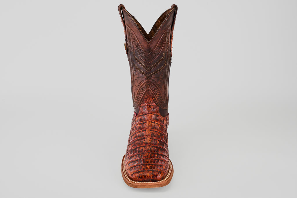 The Exotic Caiman Horn Back - Smoke Cogñac- Square Toe boot features textured caiman leather with decorative stitching, shown from the front against a plain light gray background.