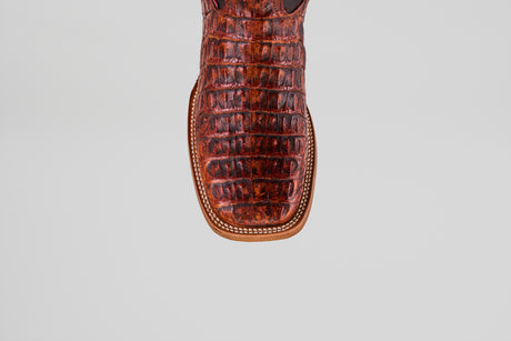 Close-up of the toe of the Exotic Caiman Horn Back - Smoke Cogñac- Square Toe boot, featuring brown, crocodile-patterned caiman leather and decorative edge stitching, set against a light gray background.