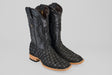 A pair of Exotic Pirarucu Fish - Matte Black - Square Toe boots featuring a scale-like texture, smooth leather shafts, light brown wooden soles, and low heels.