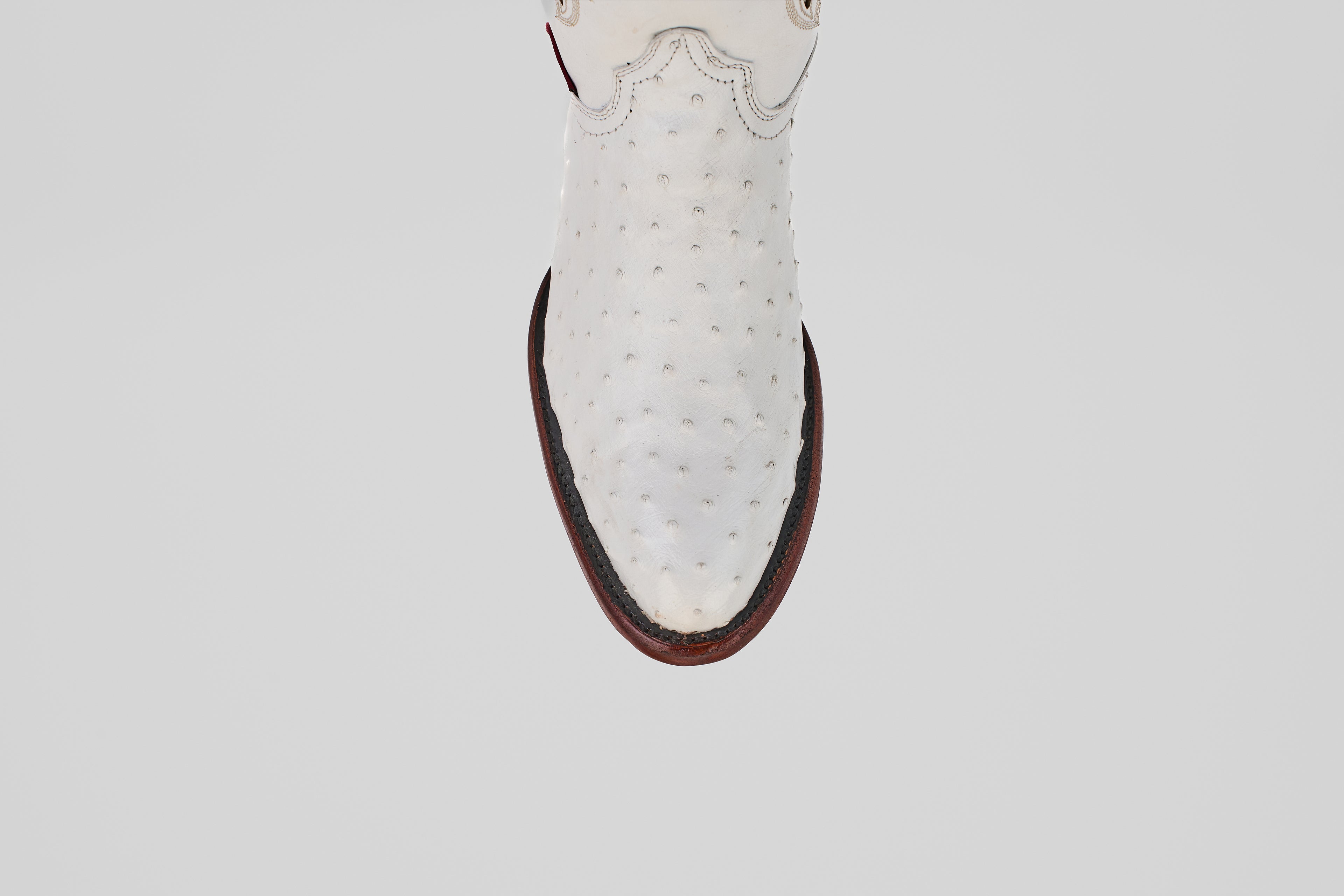 A top-down view of a single Austin - White - Round Toe ostrich leather cowboy boot with a round toe and dark brown sole, set against a plain light background.