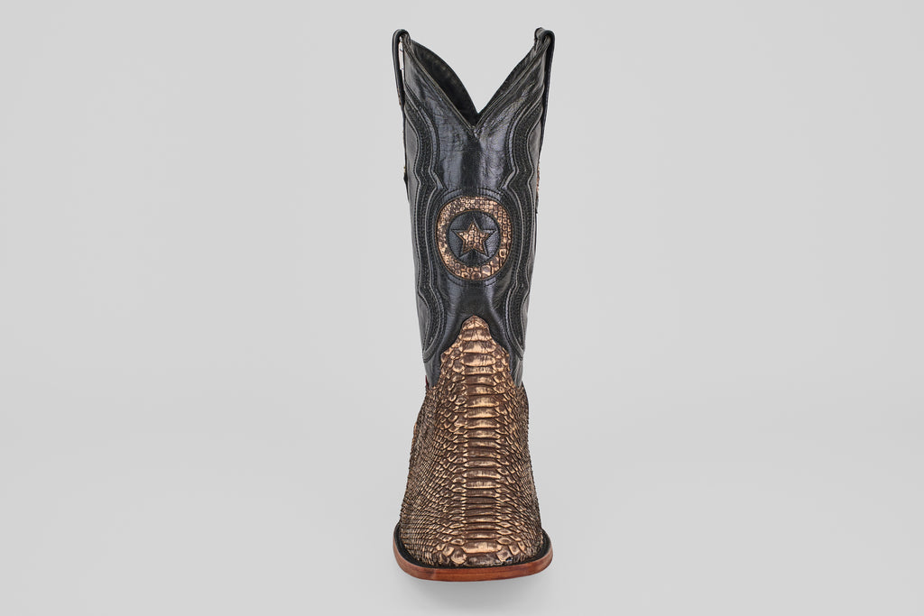 The Tanner - Rustic Bone - Square Toe cowboy boot features a brown snakeskin-textured lower, black upper shaft, and a decorative star emblem on the front—reflecting Western craftsmanship and the allure of exotic leather.