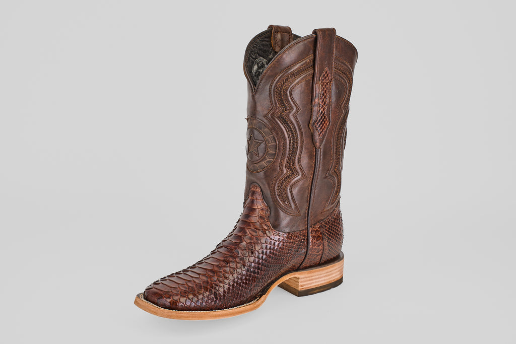 The Tanner - Brown - Square Toe boot features intricate stitching on the upper leather, a python cafe scale-like pattern on the lower part, a light wooden sole, and a square toe.