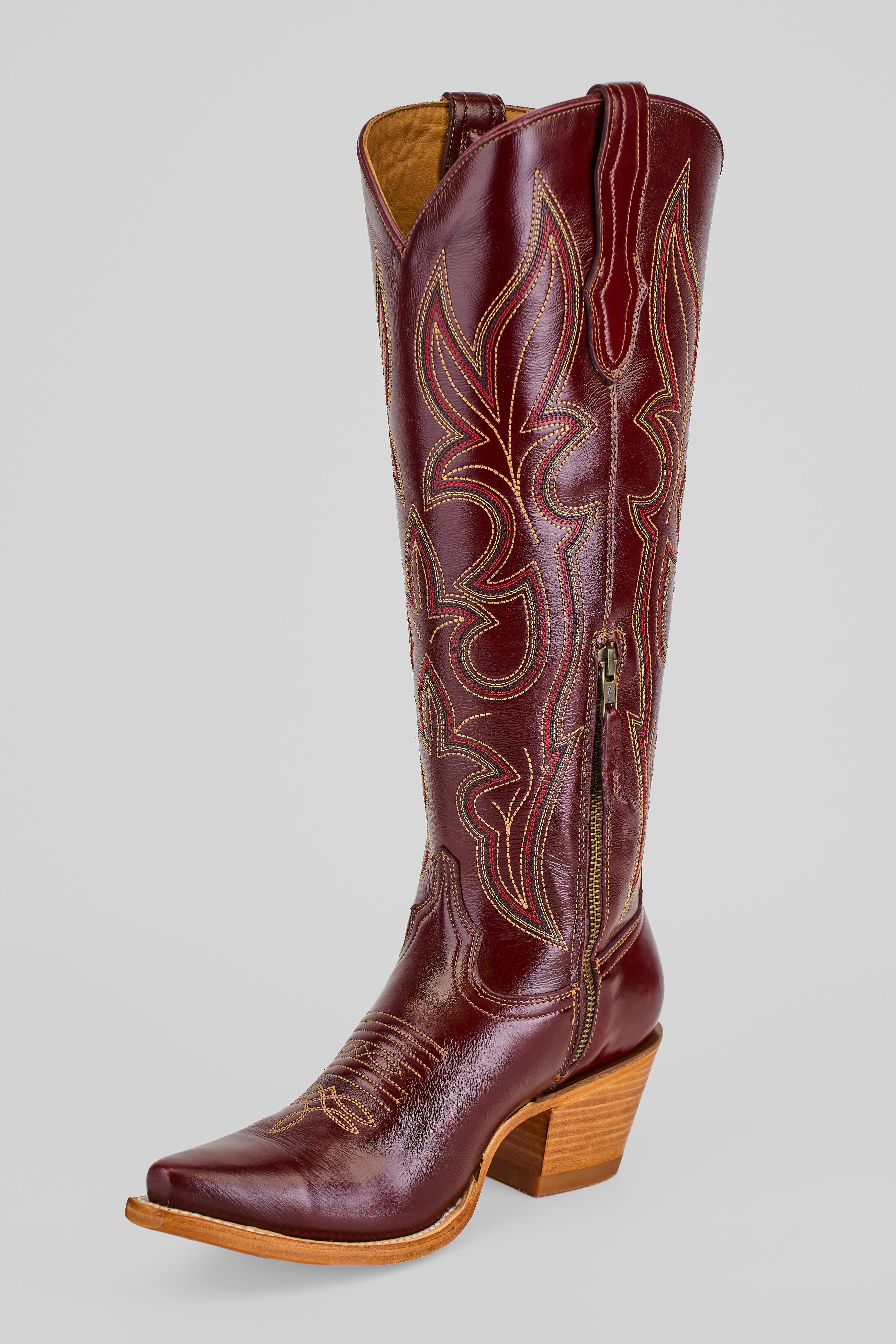 The Allison Blackberry - Tall Shaft - Snip Toe is a women's tall brown leather Western boot with decorative stitching, pointed toe, side zipper, and stacked wooden heel, shown on a plain light gray background.