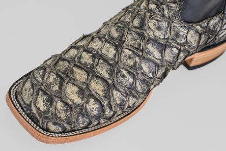 A close-up of the Conor - Rustic Bone - Square Toe men's cowboy boot, featuring textured exotic leather, detailed stitching, and a light tan sole.