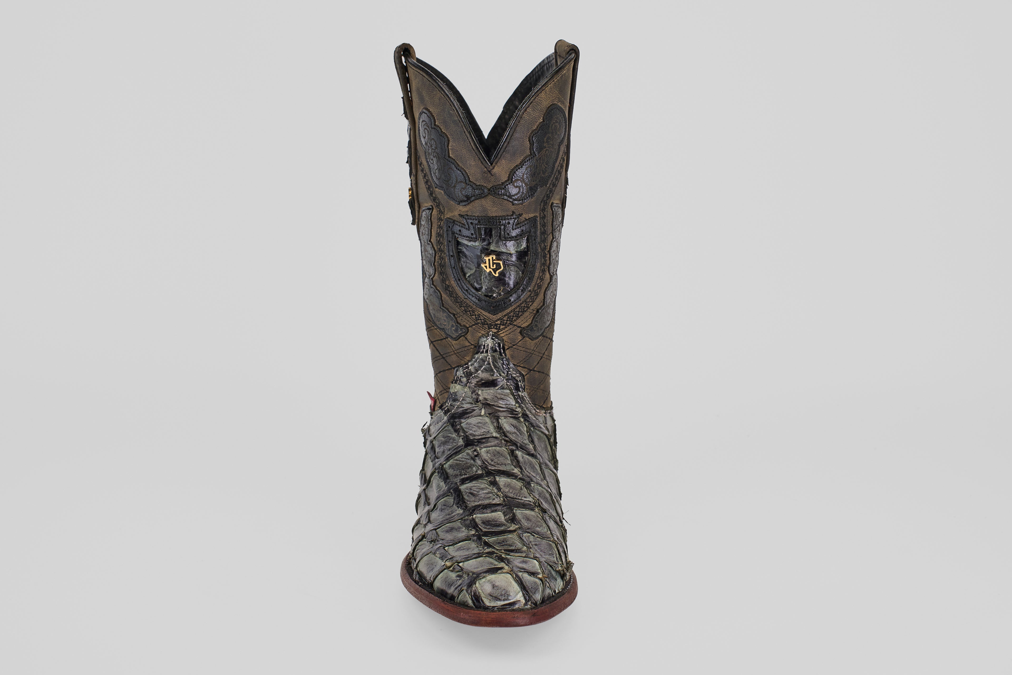 The Conor - Charcoal - Roper Toe is a single ornate cowboy boot made from textured fish leather, featuring a roper toe and bold red sole, displayed upright on a plain light gray background.
