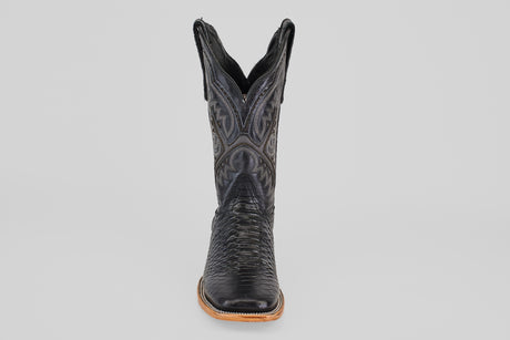 The Python Black - Embossed Leather - Square Toe (E425) cowboy boot is shown from the front, featuring detailed stitching and a textured pattern on black embossed leather against a plain light gray background.