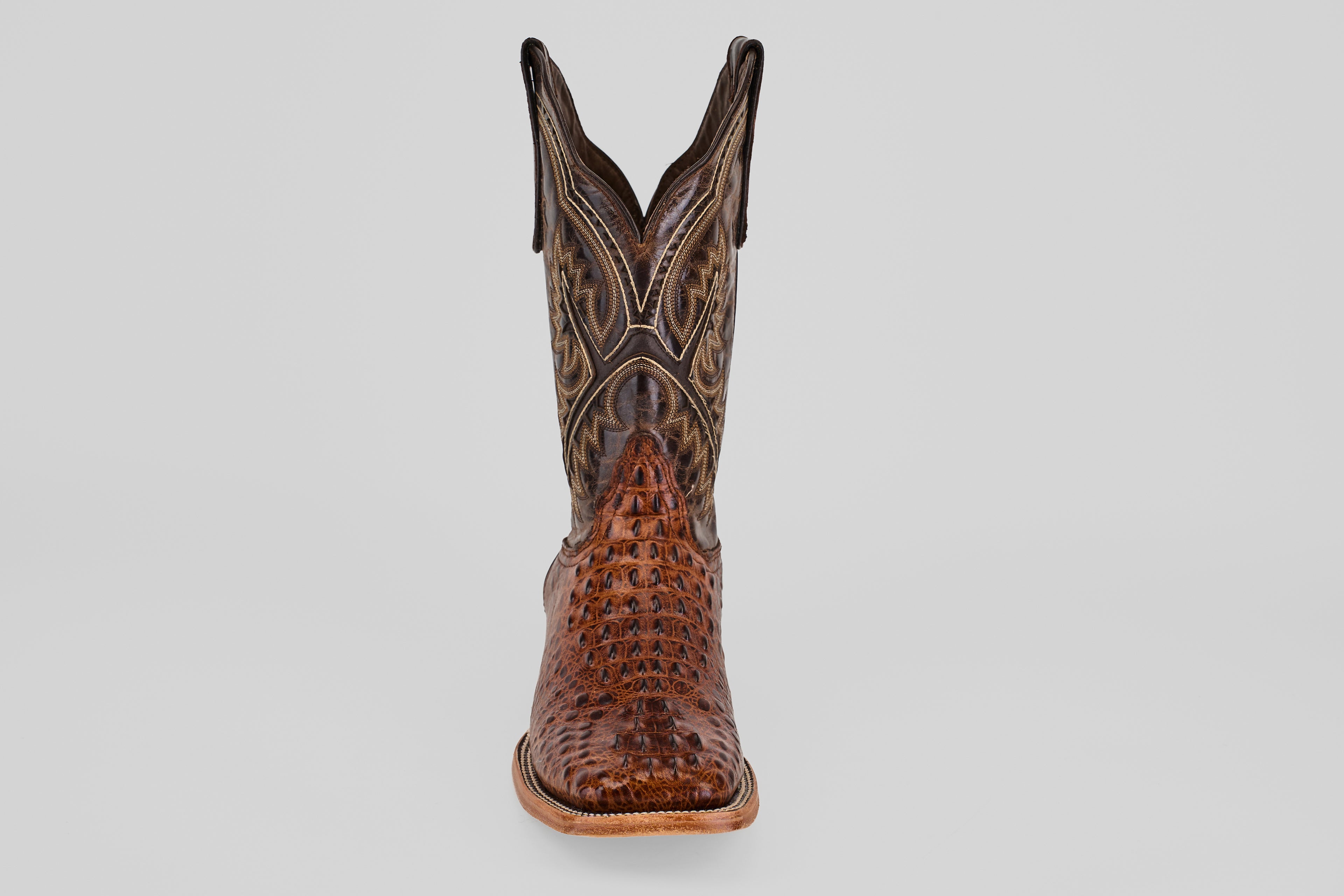 The Hornback Brown - Embossed Leather - Square Toe (E427) boot features a textured, patterned surface and dark stitching, shown front-facing on a light gray background. Ideal for anyone seeking authentic Western style boots.