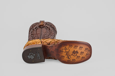 A single Conor Platinum - Buttercup - Square Toe (Herradura) cowboy boot lies on its side, displaying the “R” logo patterned sole, stitched detailing, and textured brown upper against a plain gray background.