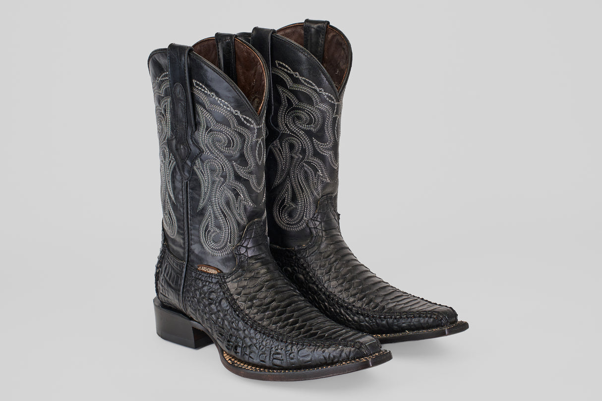 A pair of Python Black - Embossed Leather - Versy Toe (E202) cowboy boots with intricate silver stitching, pointed toes, and stacked heels is displayed on a plain light gray background.