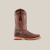 The Azkar Tan boot, featuring a rodeo toe and slip-resistant sole, is displayed solo against a white background. Made from premium cowhide leather with detailed stitching and a rustic weathered texture, it boasts a light brown wooden heel for added charm.