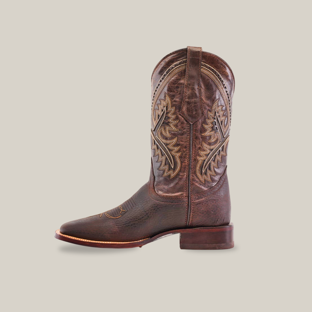 The Cheyenne Chocolate - Square Toe boot features intricate stitching, a sturdy wooden heel, and detailed embroidery against a plain white background, showcasing its craftsmanship. It faces left to highlight its traditional design.