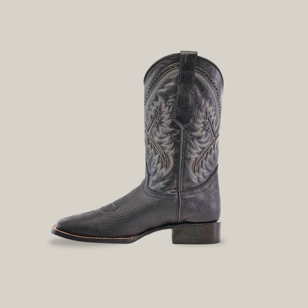 The Cheyenne Black - Square Toe boot is handcrafted from premium cowhide, featuring intricate stitching on a plain white background. It boasts a classic western design with mid-calf height and a stacked heel.