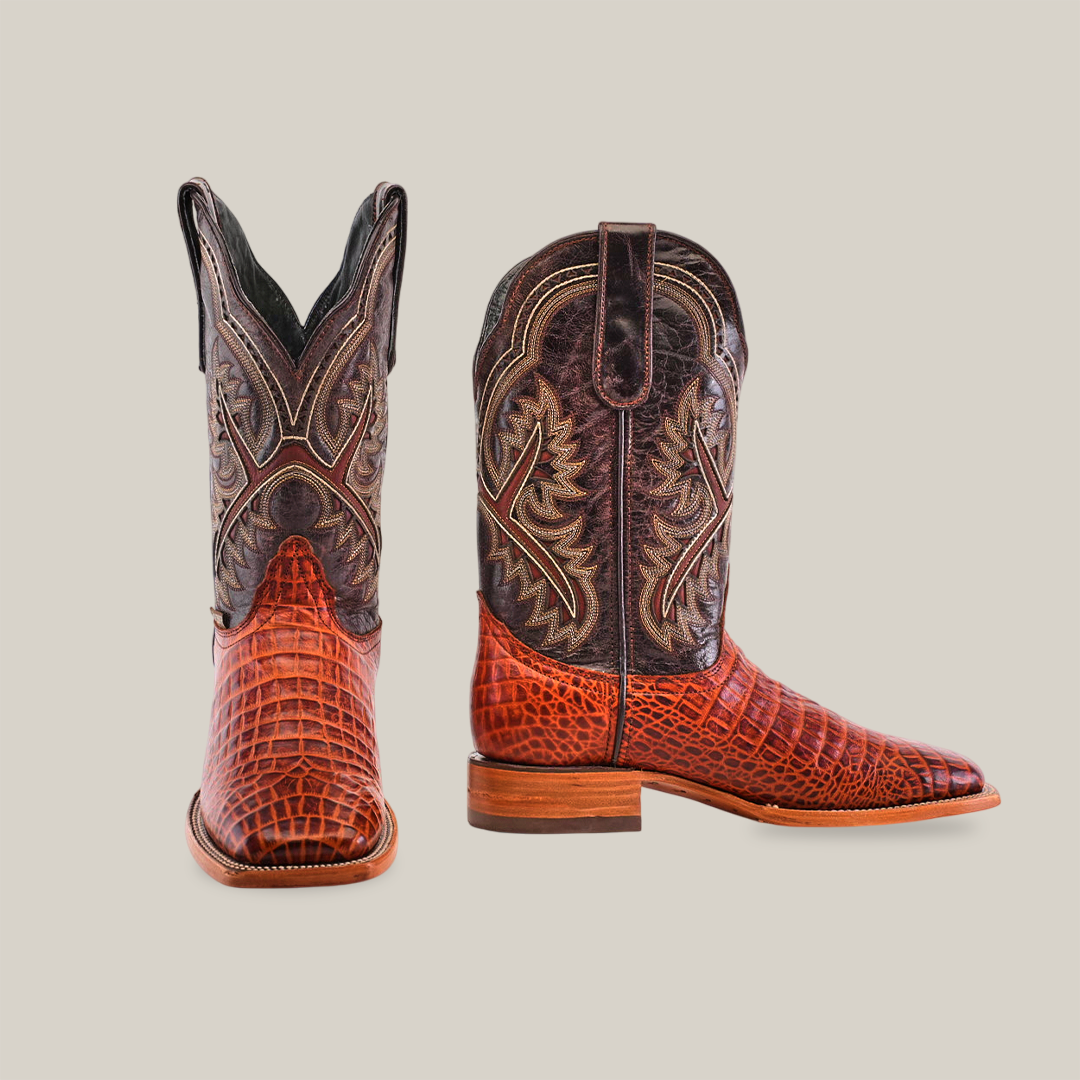 The Caiman Belly Print Cogñac - Square Toe boots, showcased from front and side, have a rich brown hue with intricate stitching and an embossed Caiman Belly design. Made from premium cowhide, they feature high shafts and thick leather soles.