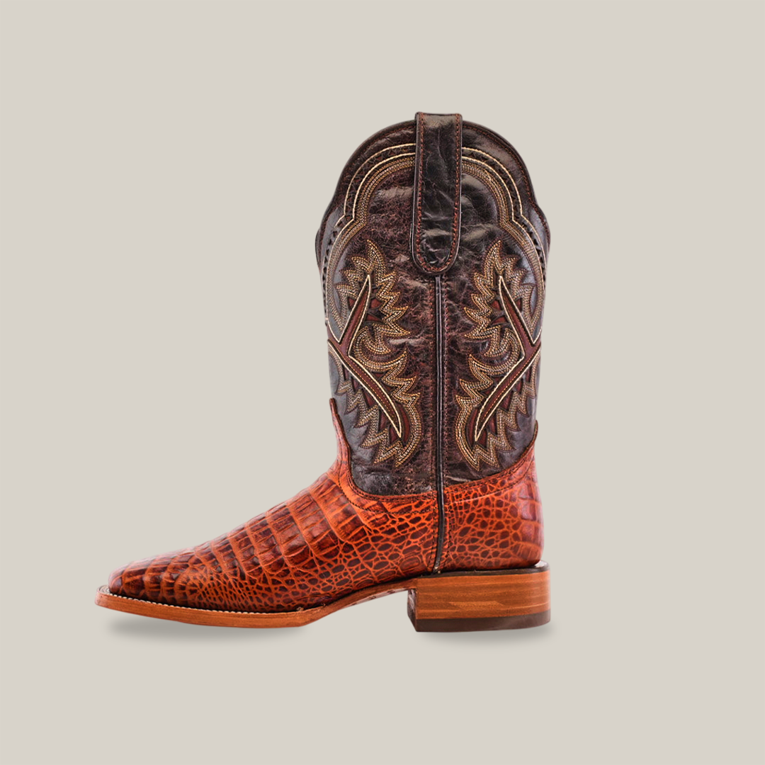 The Caiman Belly Print Cogñac - Square Toe features a textured brown lower resembling Caiman print and a dark upper with detailed stitching. This premium cowhide boot presents a cognac square toe design on a plain white background.