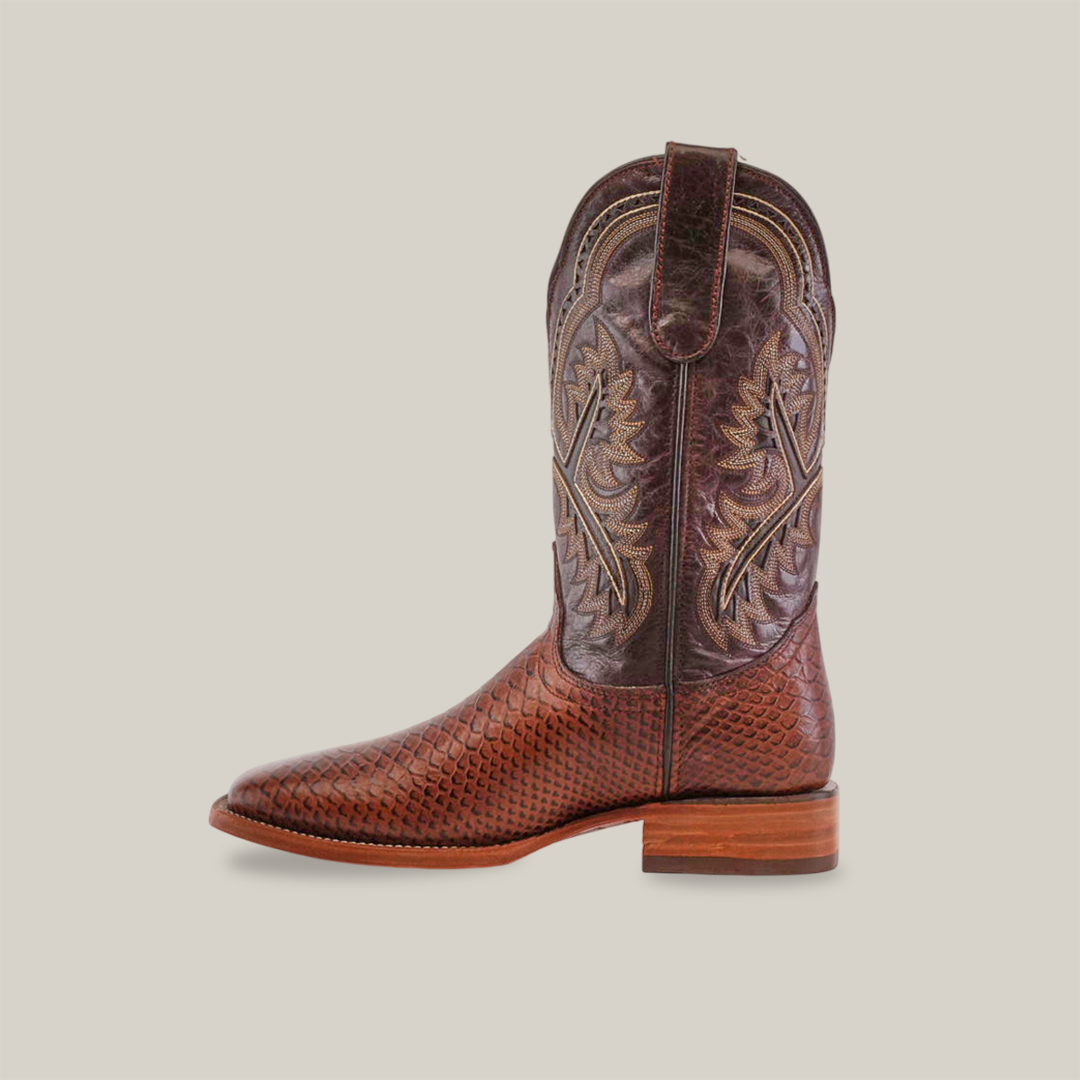 The Python Print Brown - Square Toe is a cowboy boot made from premium cowhide leather, featuring intricate stitching, textured patterns, subtle snake print accents, a square toe, low heel, and pull straps at the top for detailed craftsmanship on the shaft and foot.