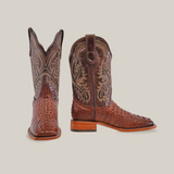 The Caiman Hornback Print Chocolate Square Toe boots are intricately designed with a rich brown hue, detailed stitching, and artisan-made textured patterns. One boot faces forward, the other in profile; they have lighter brown soles.