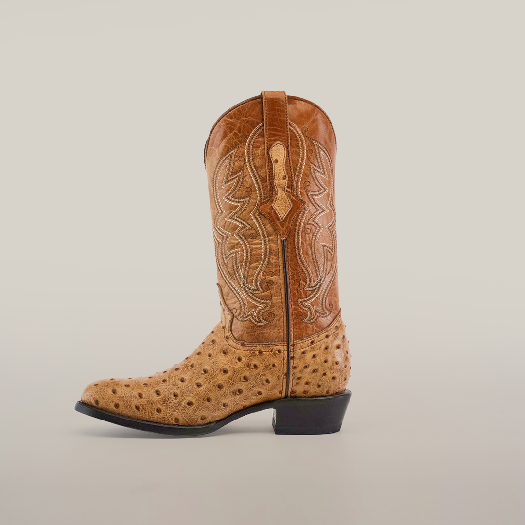 The Karoo Ostrich Print Orix, a round-toe tan cowboy boot crafted from premium cowhide, features intricate stitched patterns with a textured design and a low heel, showcased against a plain white background.