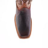 A top view of Azkar Moka boots reveals intricate stitching on the dark cowhide leather toe and an ornate design on the shaft. These boots, crafted from premium materials, feature a light brown slip-resistant sole with a visible seam around the edge.