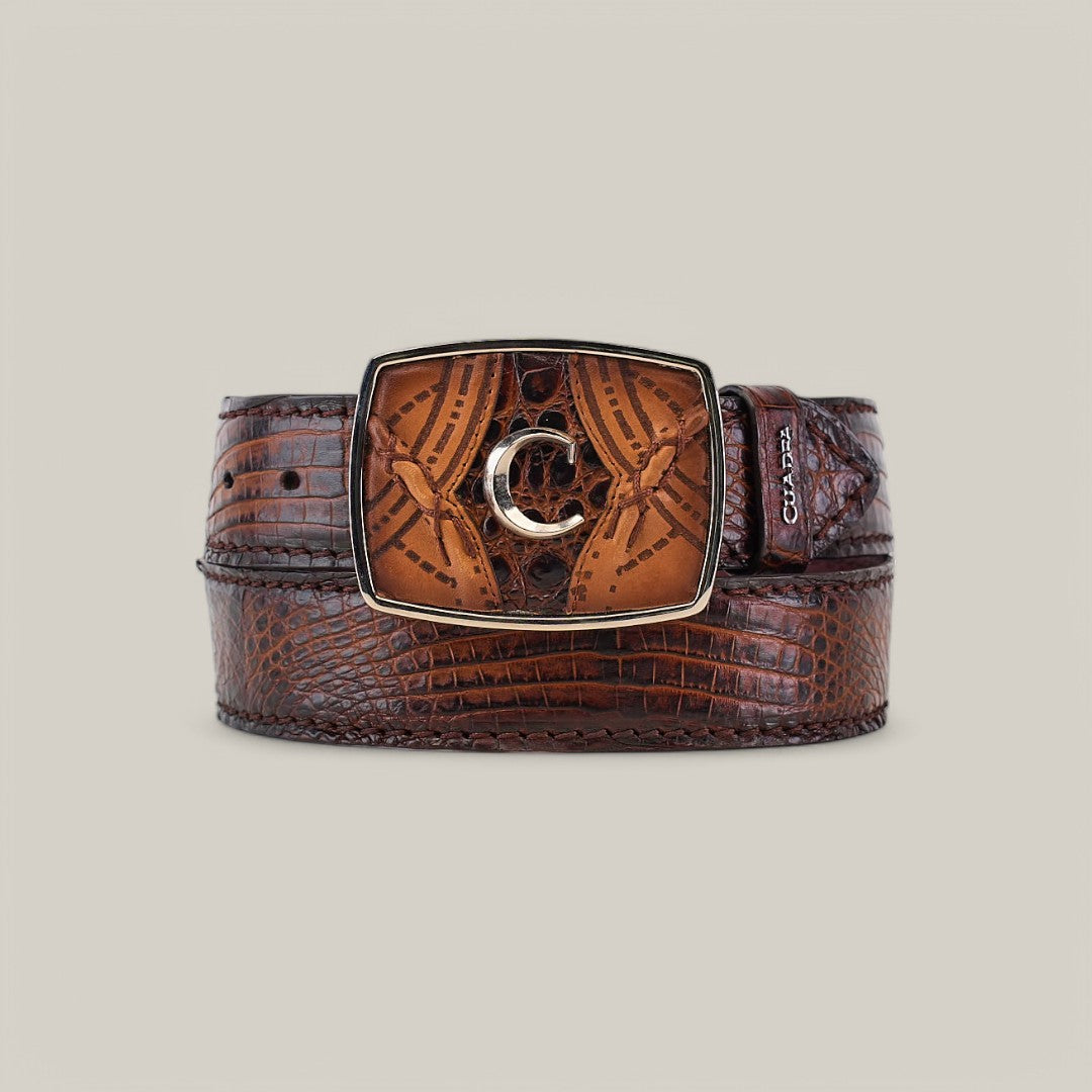 The Atlantic Straw Caiman Laser Belt - BC352 features brown caiman leather with a crocodile texture and a rectangular, ornate buckle adorned with a metallic C design.