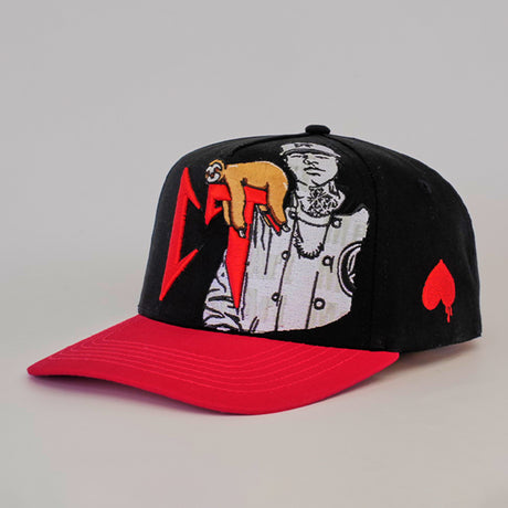 The De Rancho Cap CT Black features a black base with a red brim and embroidered designs of a person in a coat, sloth on their arm, and red lightning bolts. Embracing Western heritage, it includes a bold red spade symbol on the side.