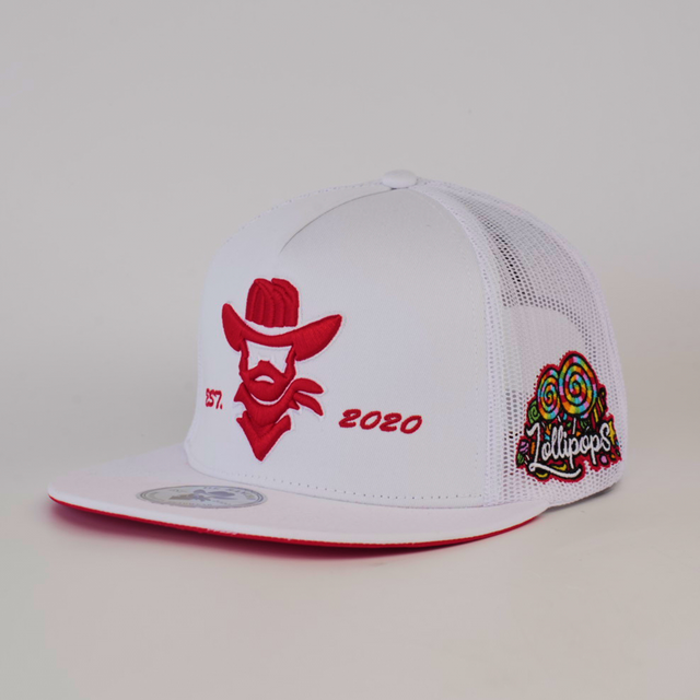 The De Rancho Cap Lollipops White is a white mesh baseball cap featuring a red embroidered cowboy face with 2020 EST. and colorful lollipops alongside the word Lollipops, creatively merging ranch culture with Western heritage.