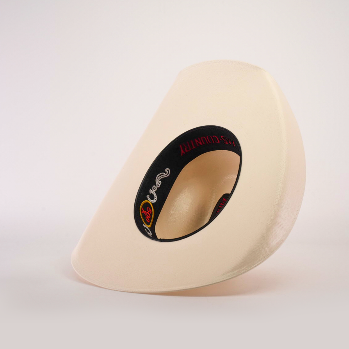 A modern cream-colored object with a unique shape and black interior, featuring a logo and red text, mirrors the playful yet refined look of the 500X Chihuahua Straw Hat, standing elegantly against a white background.