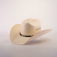 The 500X Country Straw Hat is a cream-colored cowboy hat with a classic design, showcasing a wide brim and adorned with a black band with metallic accents, made from premium materials, set against a plain white background.